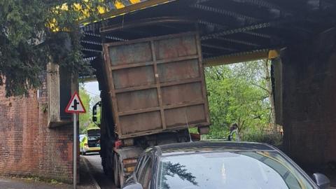 lorry wedged under bridge