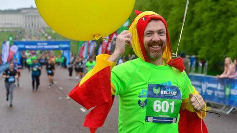 a man runs in the marathon in a bright costume