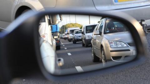 Cars reflected in a wing mirror