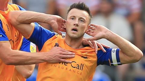 Ollie Clarke celebrates scoring a goal for Mansfield Town