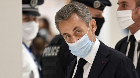 Image shows former French president Nicolas Sarkozy arriving for the opening hearing of his trial