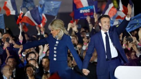 Brigitte Macron and French President Emmanuel Macron celebrate after securing a second five-year term as president