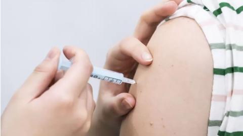 Close up of someone receiving a vaccine on their arm