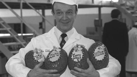 Walter Willen holds Easter eggs decorated for the Queen's grandchildren