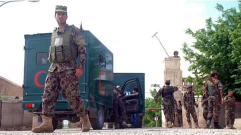 Afghan soldiers stand guard as military ambulances enter a military base a day after it was targeted by the militants in Balkh province, Afghanistan, 22 April 2017