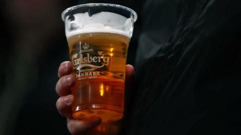 Man holding a pint of Carlsberg