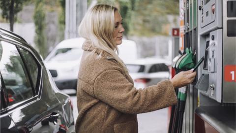 Woman paying for petrol at pump
