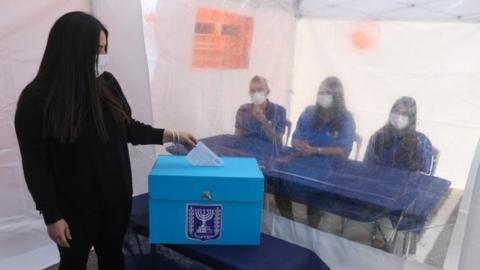 Woman demonstrates casting her vote at a Central Election Commission event in Shoham, Israel (23/02/21)