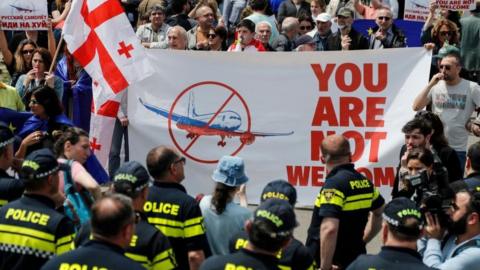 People protest the resumption of air links with Russia during the arrival of the first direct flight of the Russian airline Azimuth, from Moscow to Tbilisi International Airport, in Tbilisi, Georgia