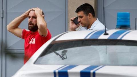 A medical worker reacts at a crime scene of a mass shooting in which 12 people, including the gunman, were killed, according to local media reports, in Cetinje, Montenegro August 12