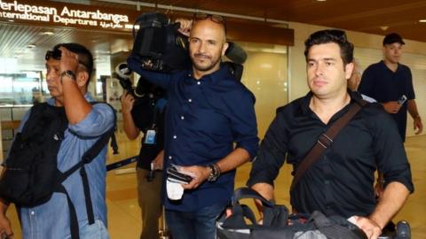 Australian Broadcasting Corp. television reporter Linton Besser, right, and camera operator Louie Eroglu, centre, prepare to leave at the Kuching International Airport in Sarawak, Malaysia, Tuesday, March 15, 2016.