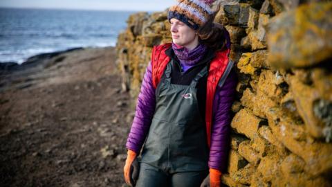 Sian Tarrant in front of stone wall