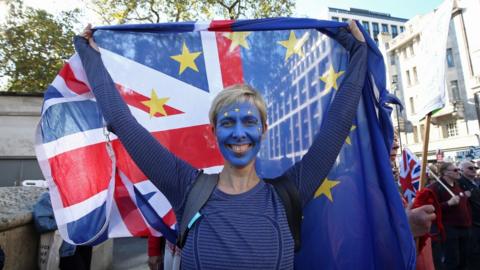 An anti-Brexit campaigner with her face painted in the colours of the European Union flag takes part in the People"s Vote March for the Future in London, a march and rally in support of a second EU referendum.
