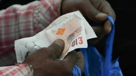 Shopper holding £10 notes