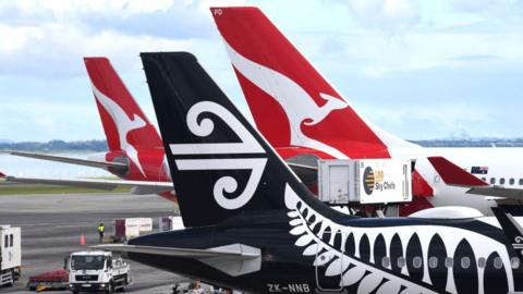 Tails of Qantas and Air New Zealand jets on the tarmac in Sydney.