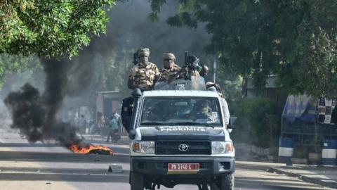 Chad policemen patrol in a vehicle during clashes with opposition demonstrators in N'Djamena