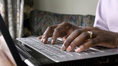 Unidentified woman typing on laptop computer