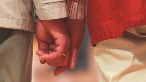 Elderly couple holding hands