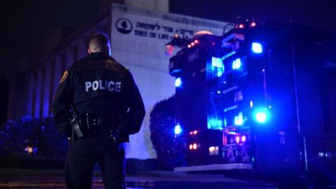 A police officer stands outside the synagogue