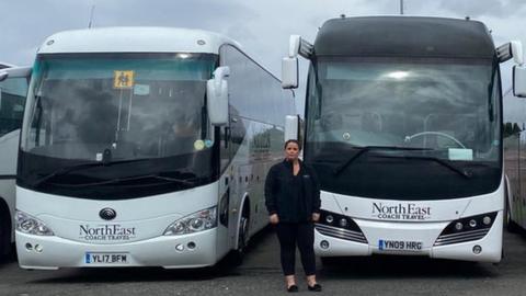 Jenna Rush, managing director of North East Coach Travel, stands by a fleet of vehicles