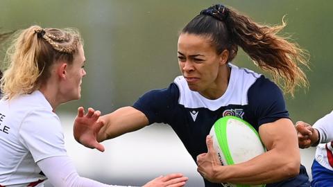 Great Britain's Deborah Fleming hands off a player while running with the ball