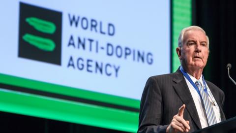 Wada president Sir Craig Reedie speaks at a conference in front of the organisation's logo