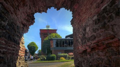 The Mercury Theatre and Jumbo water tower seen through an arch of the Roman wall in Colchester