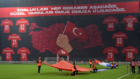 A giant banner of the Turkish map and Turkish city names that are affected by earthquakes displayed at Turkey's game against Croatia