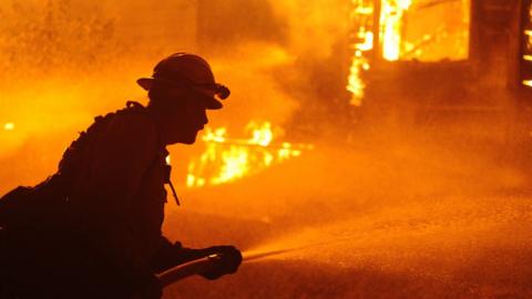 Firefighters try to extinguish Dixie Fire near Chico in Greenville, California, United States on August 5, 2021. The Dixie Fire took a turn for the worse Wednesday afternoon. Shortly after 1 PM the winds picked up and the fire broke out of the containment lines that firefighters had established south of the town of Greenville.