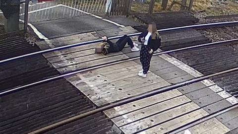 Girl lies on railway line