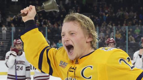 Bobcats captain Zach Metsa rings the bell after winning the Belpot Trophy