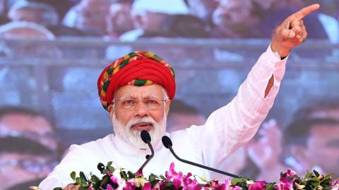 This handout photograph released by India"s Press Information Bureau (PIB) on March 4, 2019, shows Indian Prime Minister Narendra Modi addressing a gathering during during the inauguration of various development projects in Jamnagar, in the Indian state of Gujarat.