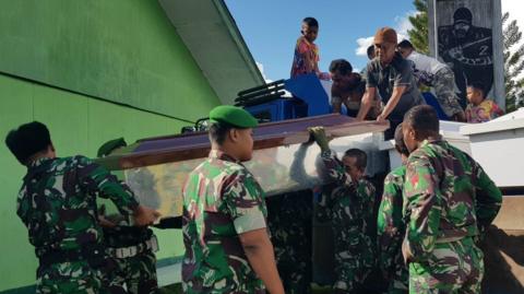 Indonesian soldiers prepare coffins for construction workers, believed to have been shot dead in Papua province on December 4, 2018