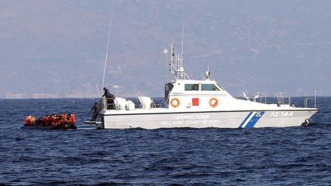 A migrant boat is rescued by a Greek coastguard vessel as it makes the crossing from Turkey to the Greek island of Lesbos in 2015