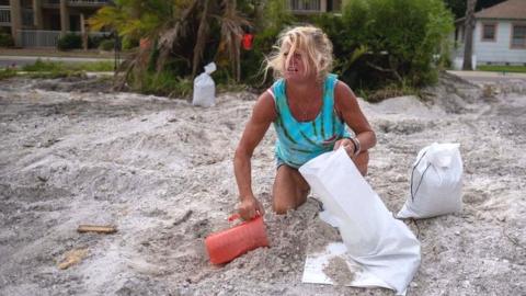 Barbara Schueler fills sandbags in a vacant lot in preparation for Hurricane Ian in St. Pete Beach, Florida on September 26, 2022