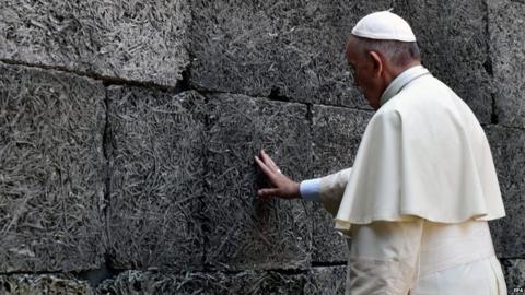 Pope Francis prays at the Death Wall