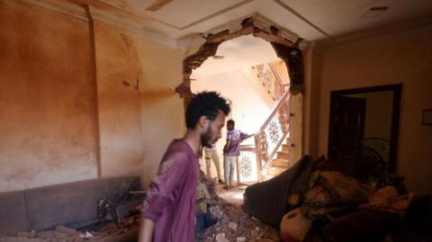 A man looks at the damage inside a house during clashes between the paramilitary Rapid Support Forces and the army in Khartoum, Sudan April 17
