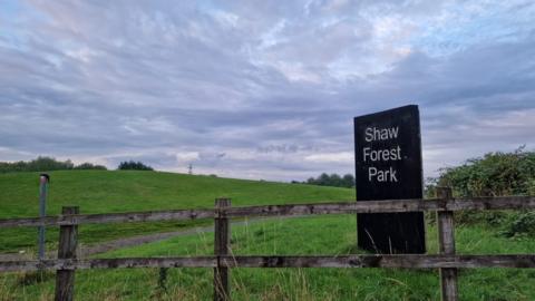 The Shaw Forest Park sign behind a fence