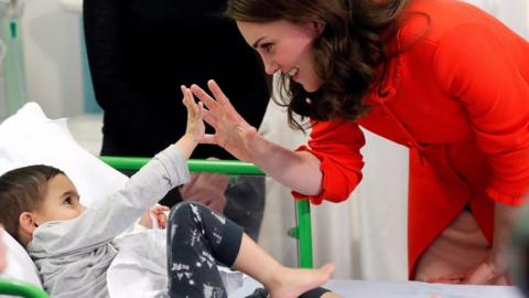 The Duchess of Cambridge and a child.