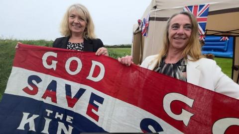 Jane Glover and Kirrie Jenkins holding a God save the King banner