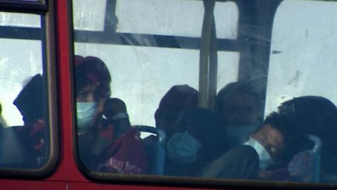 Migrants asleep on board double decker bus at a Kent processing centre