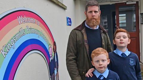 A parent and his two sons at Kingsmills Primary School