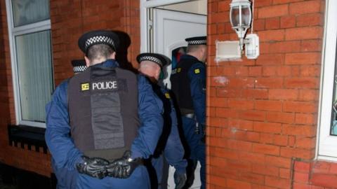 Police officers in raid on house