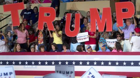 Supporters of Republican presidential candidate Donald Trump waving signs prior to the start of a rally in Roanoke, on 24 September 2016.