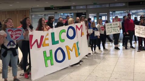 People stand with banners in Dublin airport