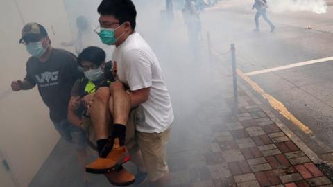 Anti-government protesters run away from tear gas during a march against Beijing's plans to impose national security legislation in Hong Kong, 24 May 2020