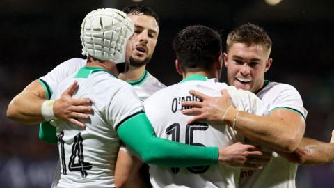 Ireland's fullback Jimmy O'Brien is congratulated by team-mates after scoring his side's opening try