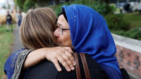 A woman embraces the relative of a victim after Friday"s mosque attacks, outside Masjid Al Noor in Christchurch, New Zealand, March 16, 2019.