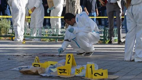 Tunisian forensics experts inspect the site of a suicide attack in the Tunisian capital Tunis