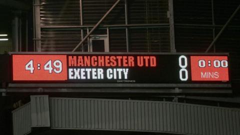 The scoreboard at Old Trafford showing Exeter City holding Manchester United to a 0-0 draw in the FA Cup in 2005